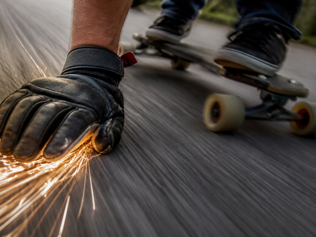 Downhill longboarder performing a speed-check slide on a steep road.
