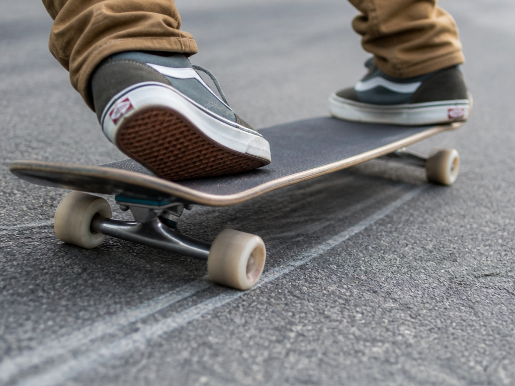 Longboard freeriding slide with kicktail and rounded wheels in action.