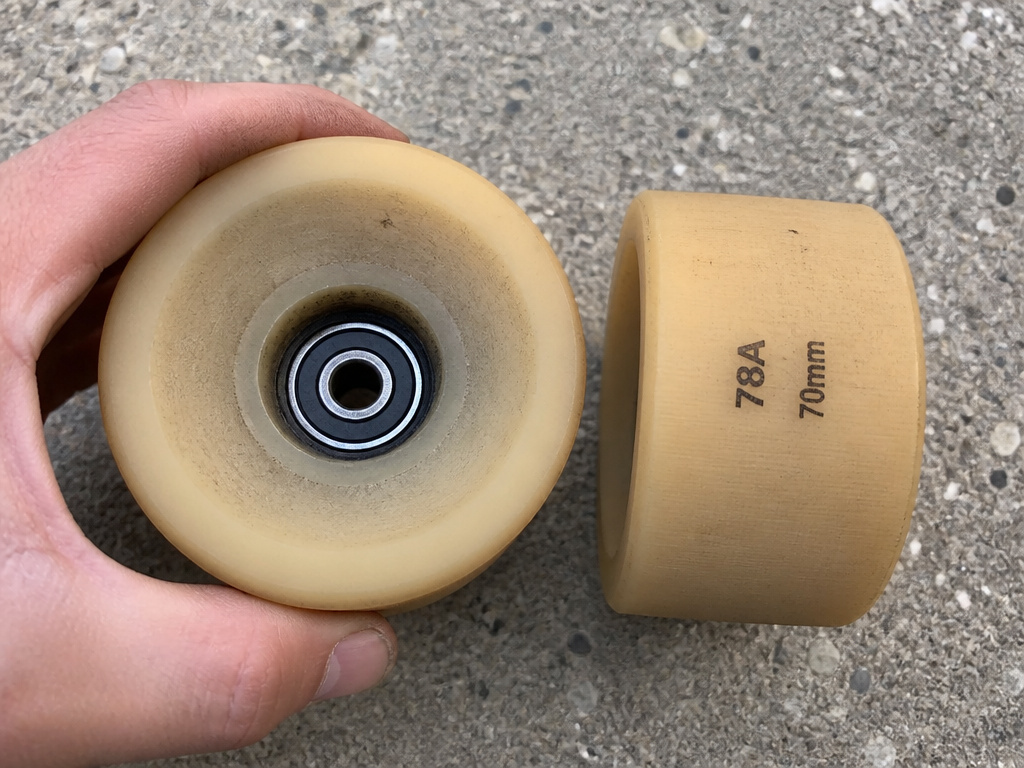Close-up comparison of longboard wheel diameter and hardness for choosing a board.