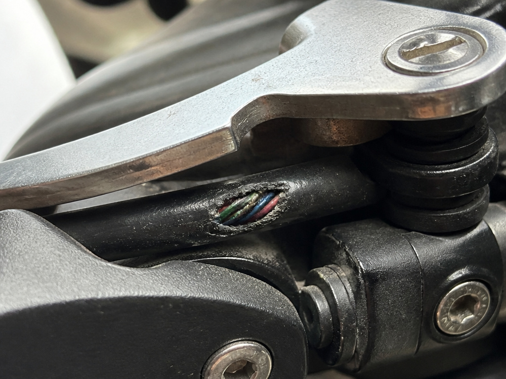 Close-up of worn wiring under the Jetson Omega scooter's folding latch.