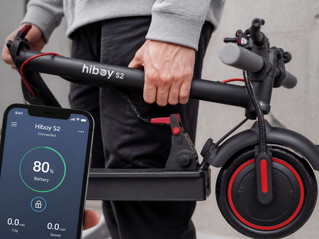 Folded Hiboy S2 electric scooter being carried and connected to mobile app.