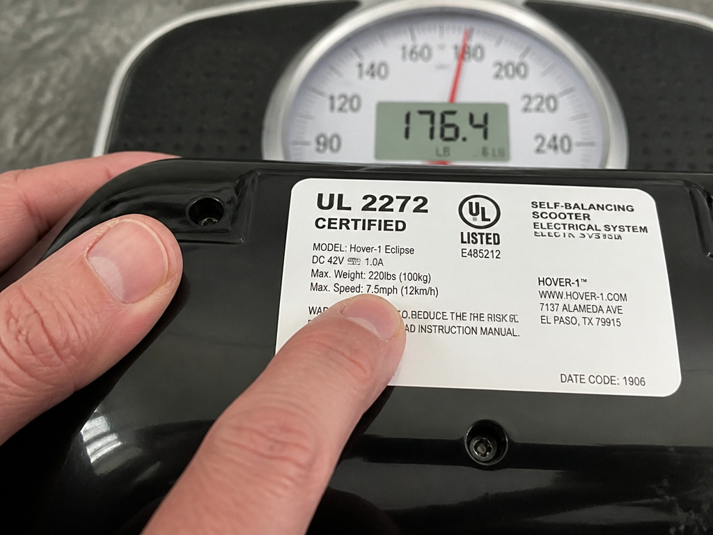Close-up of UL 2272 safety certification label next to a weight scale.