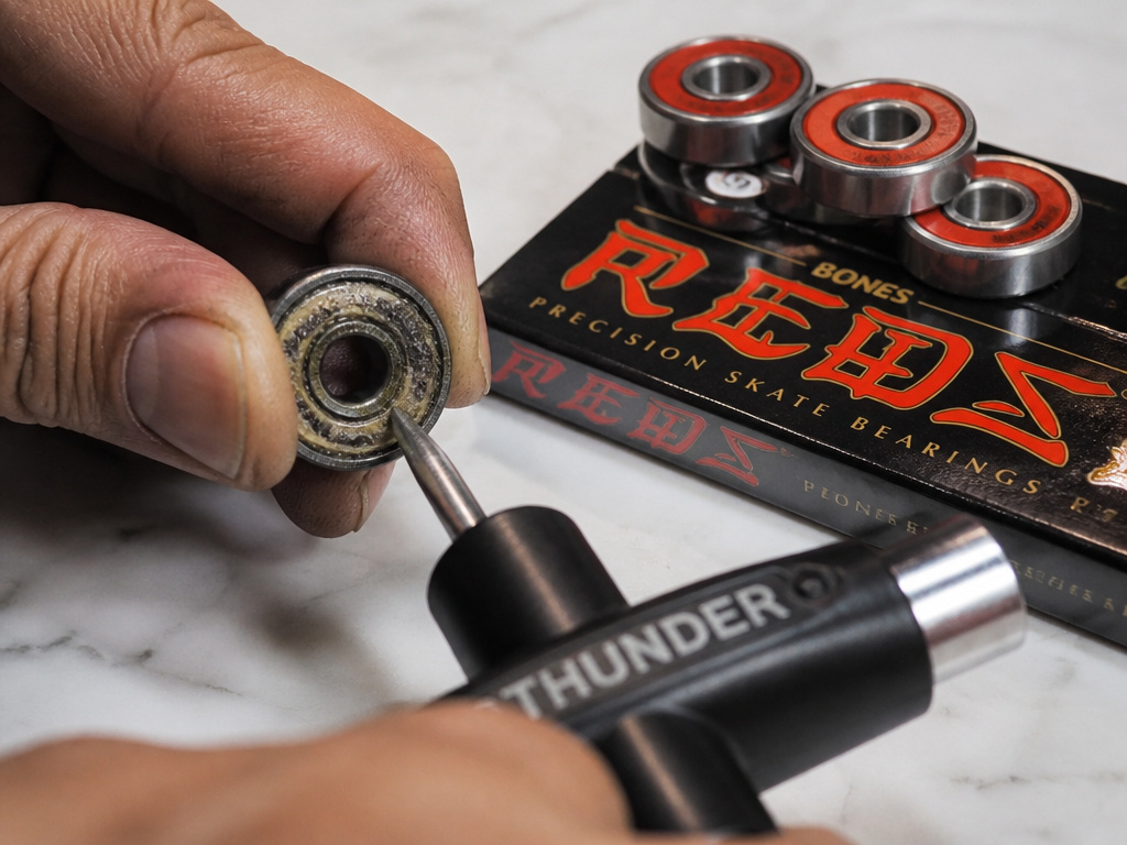 Upgrading gritty bearings on a Retrospec longboard with Bones Reds.