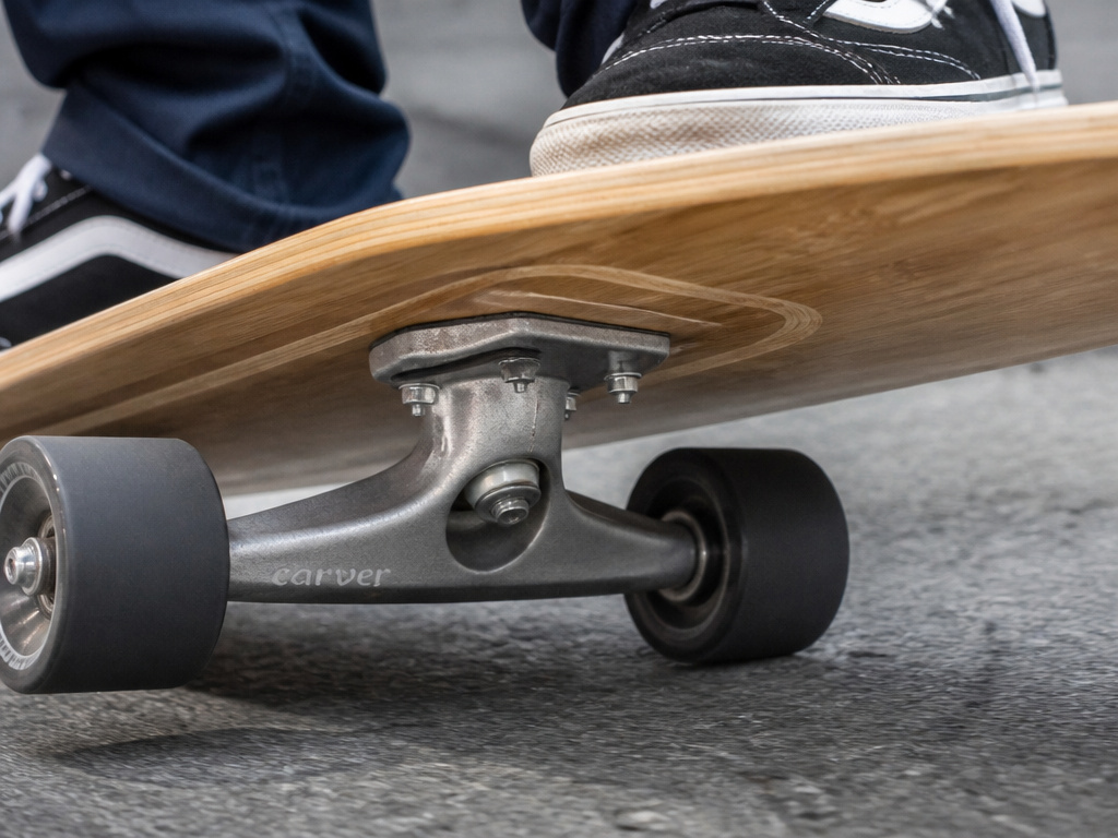 Magneto drop-through longboard truck mounting and deck construction close-up.