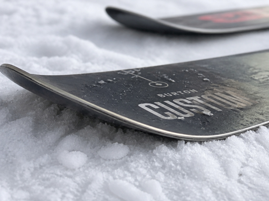 Burton Custom Camber snowboard profile compared to a rockered board on snow.