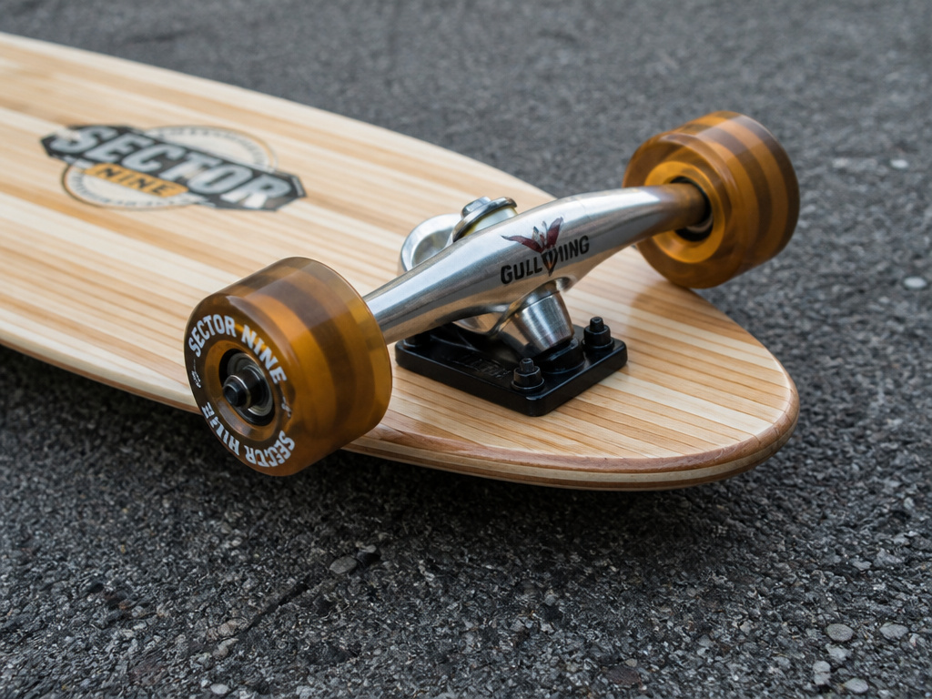 Close-up of Sector 9 longboard deck, Gullwing trucks, and wheels as a complete setup.