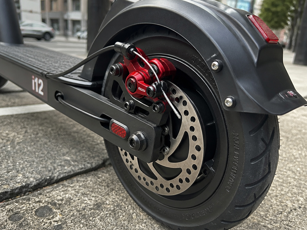 Close-up detail of iScooter i12's motor, wheel, and disc brake system.