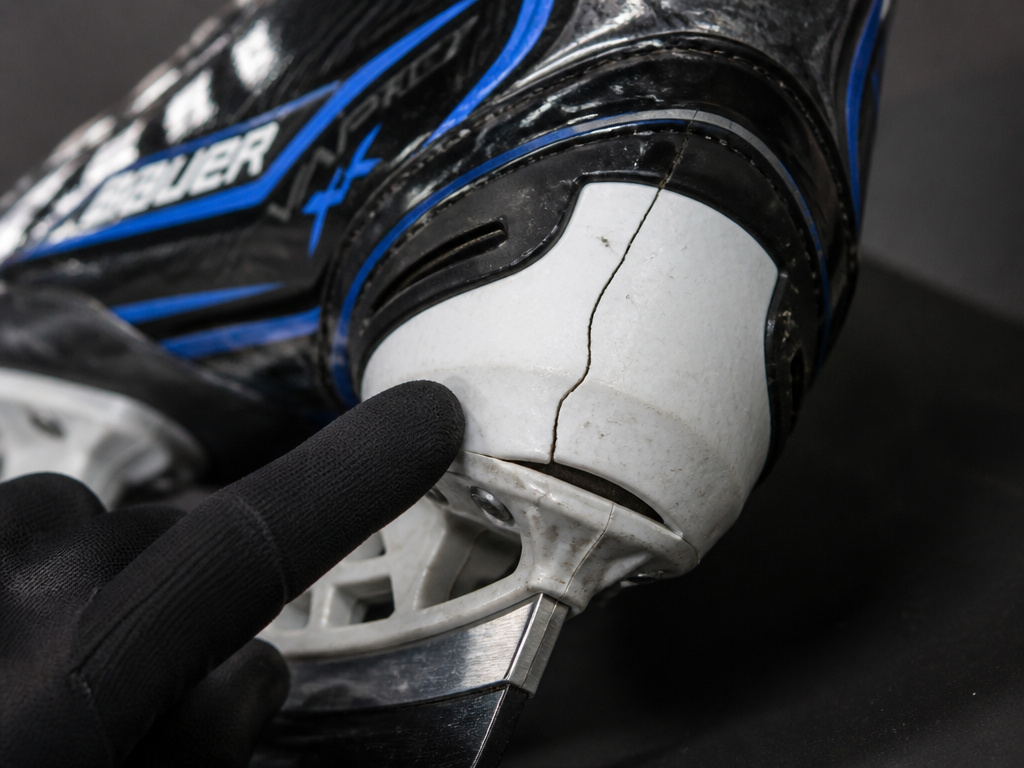 Close-up of a cracked tendon guard on a Bauer Vapor X4 hockey skate.