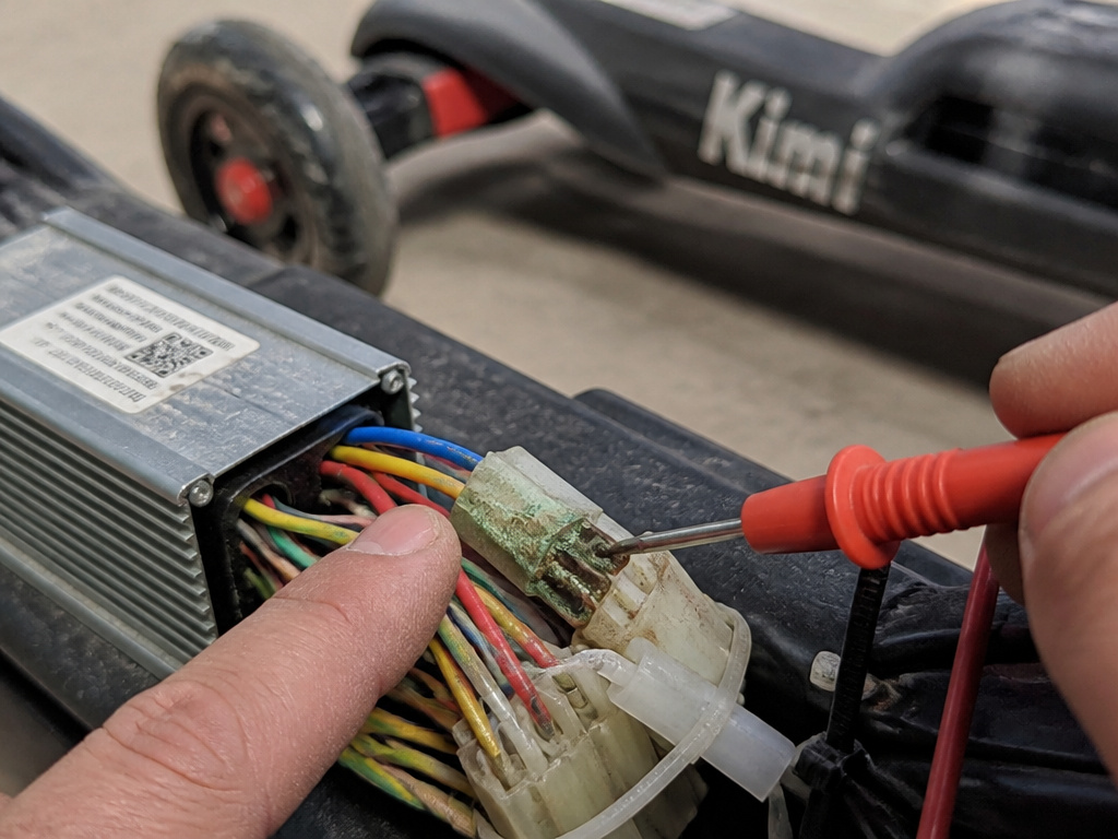 Close-up of electric scooter controller wiring and potential corrosion points.