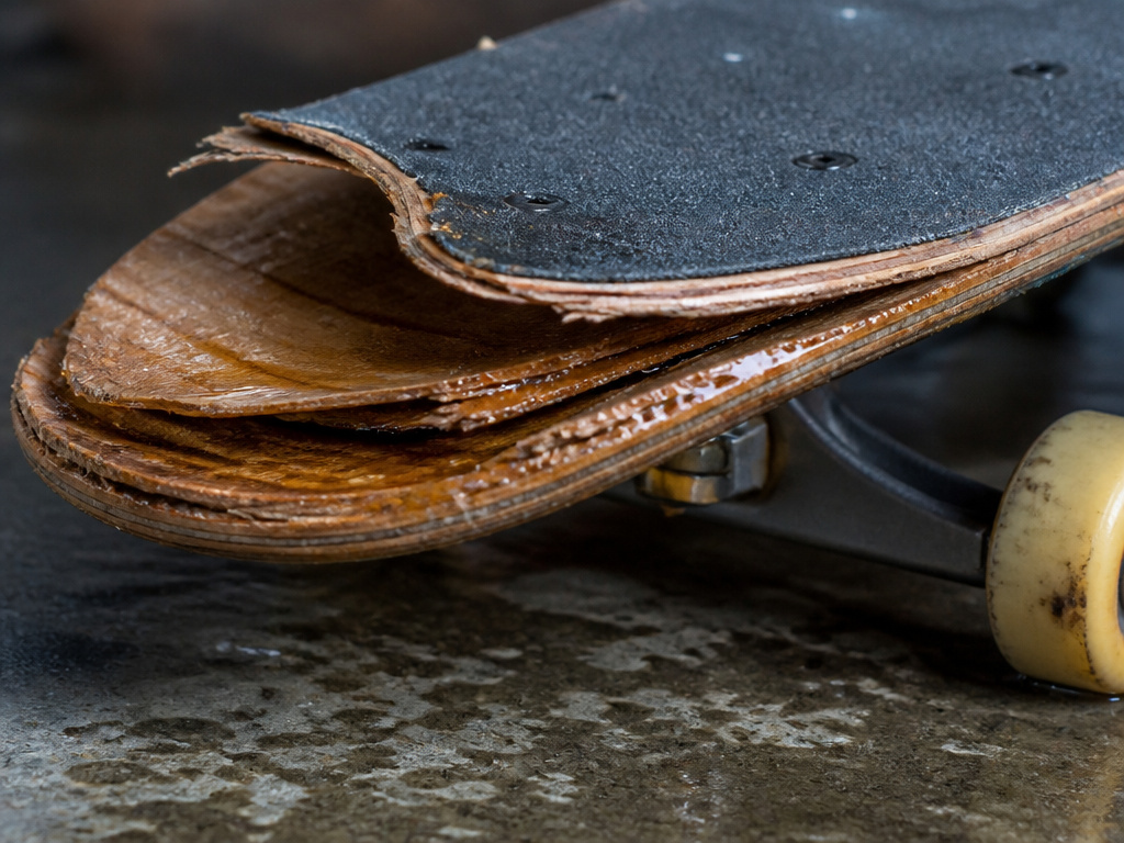 Delaminated skateboard deck showing damage from moisture and heat.